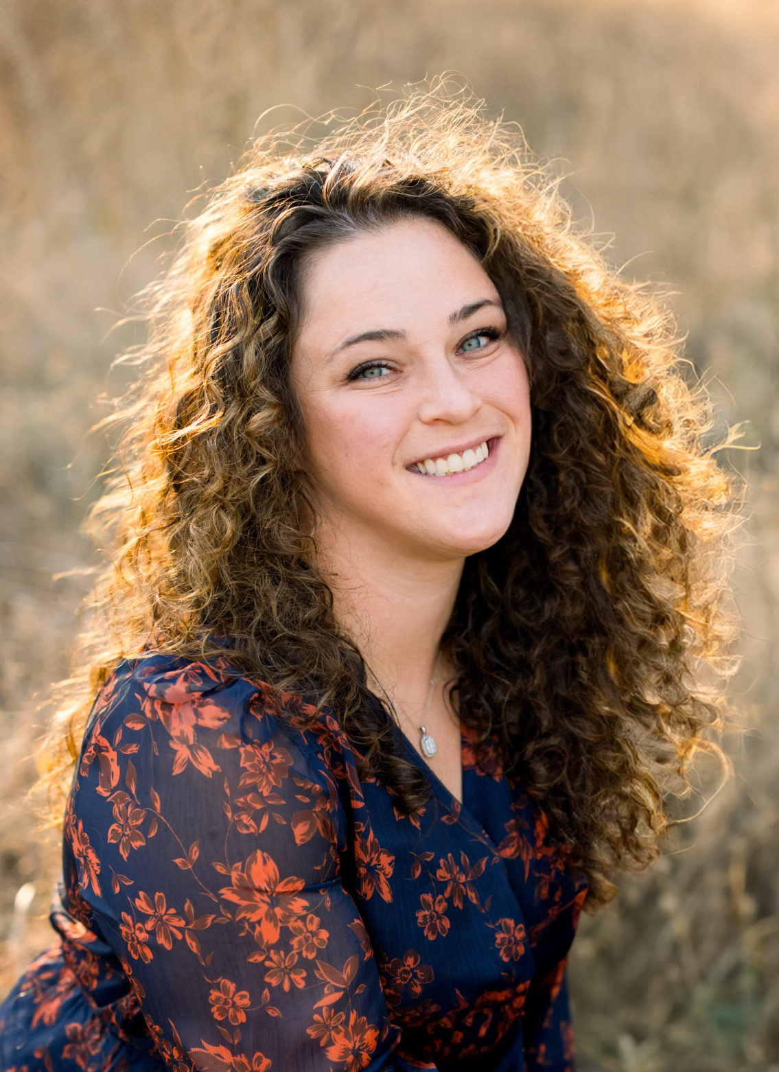 Smiling woman with curly hair outdoors